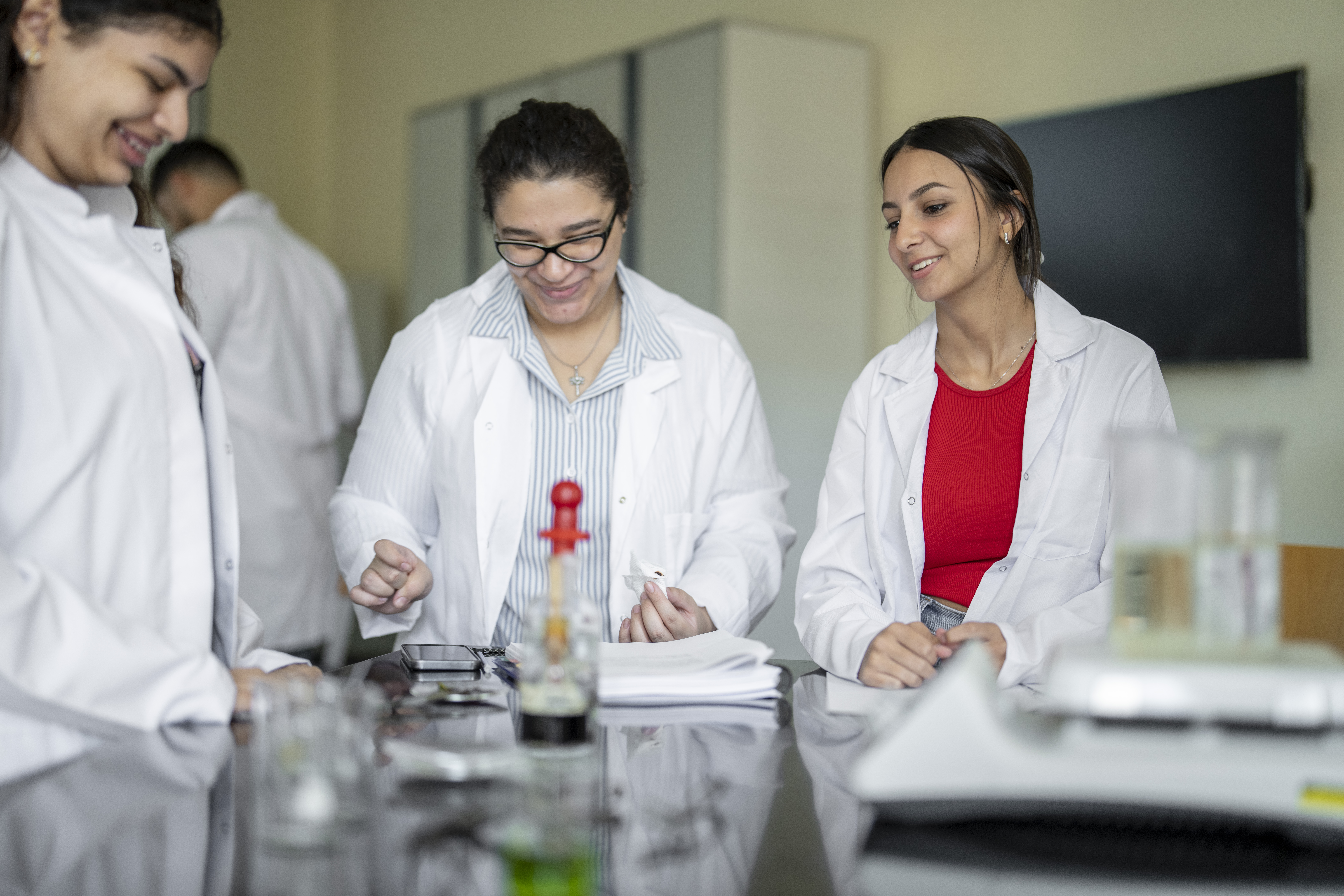 group of students in lab working on chemicals wearing white coats