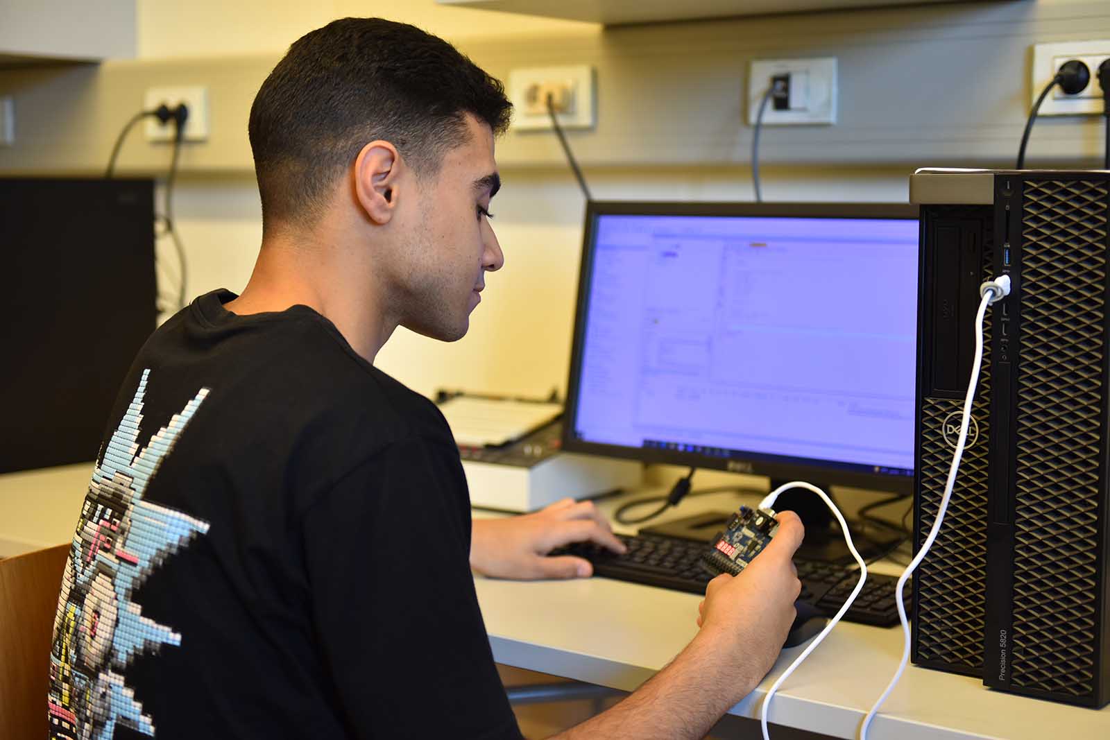Student working with electronic equipment in lab