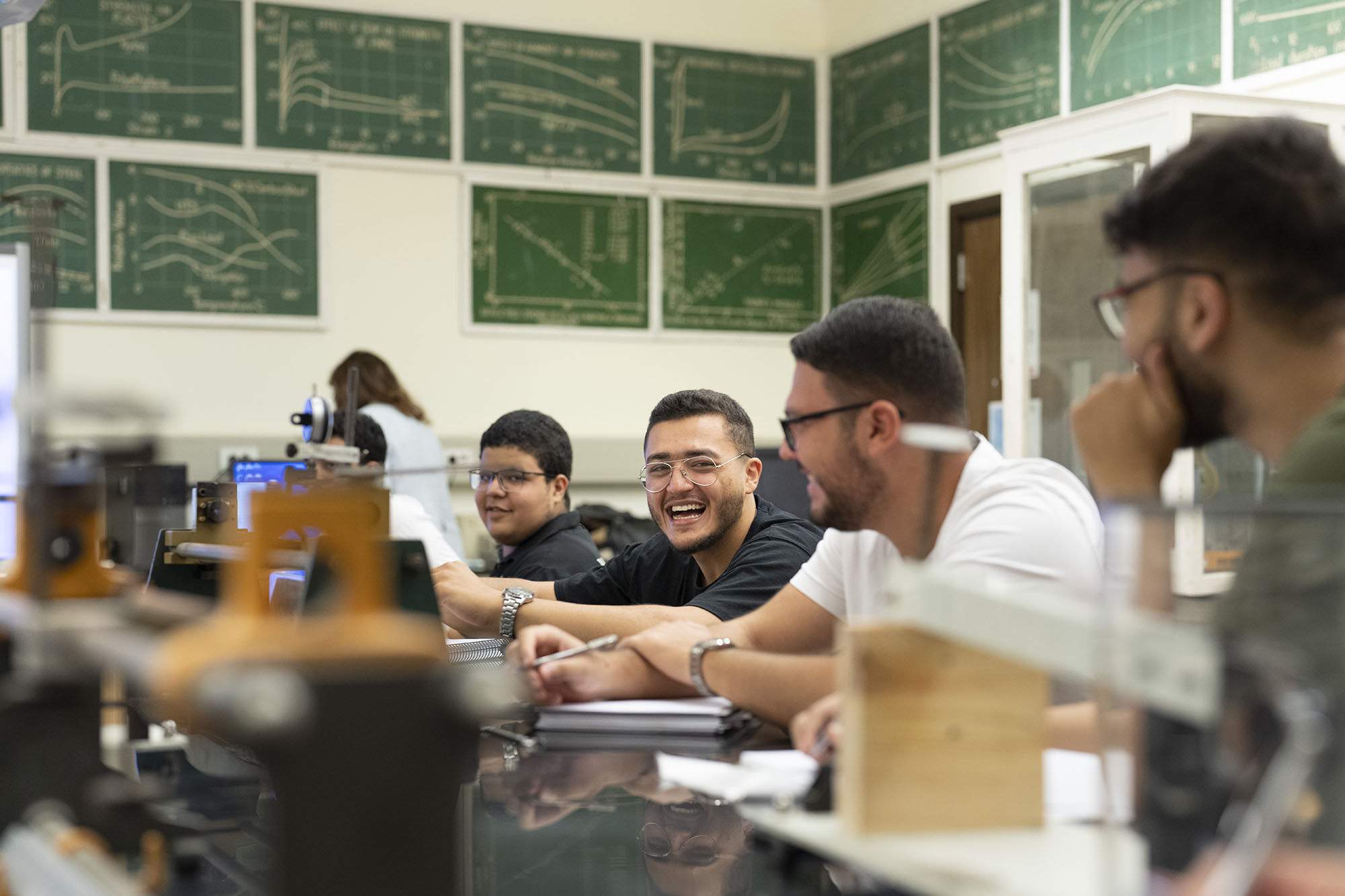 mechanical engineering graduate program image of smiling group of male students talking about a topic in class lab