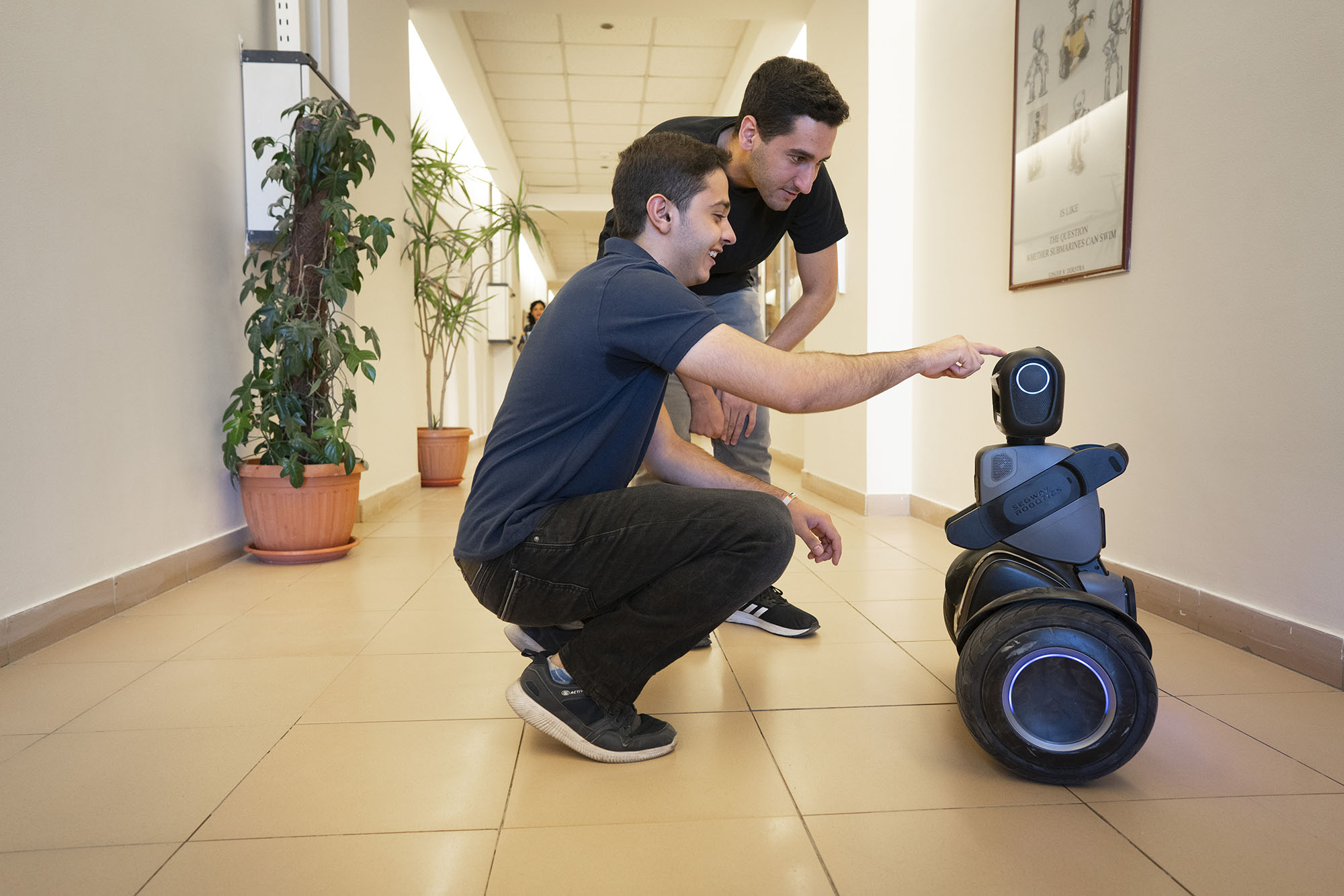 smiling students working with a robot 