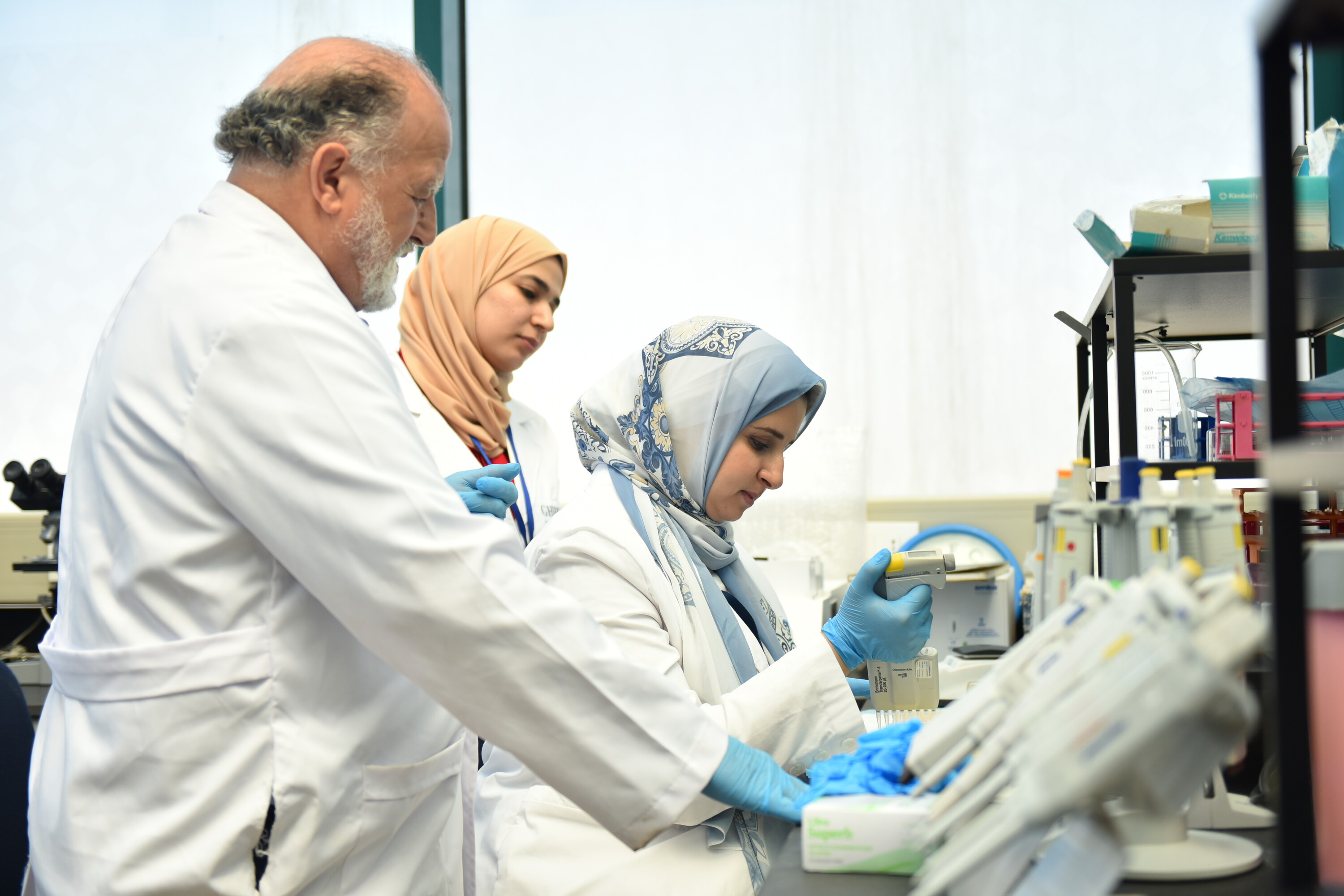 Hassan fawal and lab employees working in Human Ecology Lab with white coats