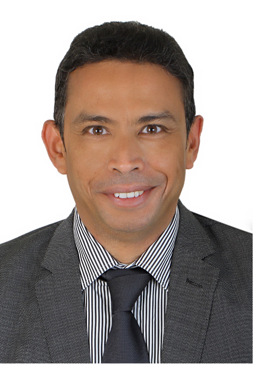 Headshot of a man smiling wearing a suit and tie