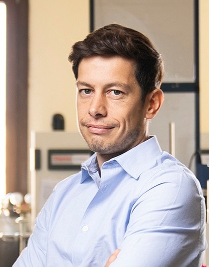 headshot of a man smiling in a lab