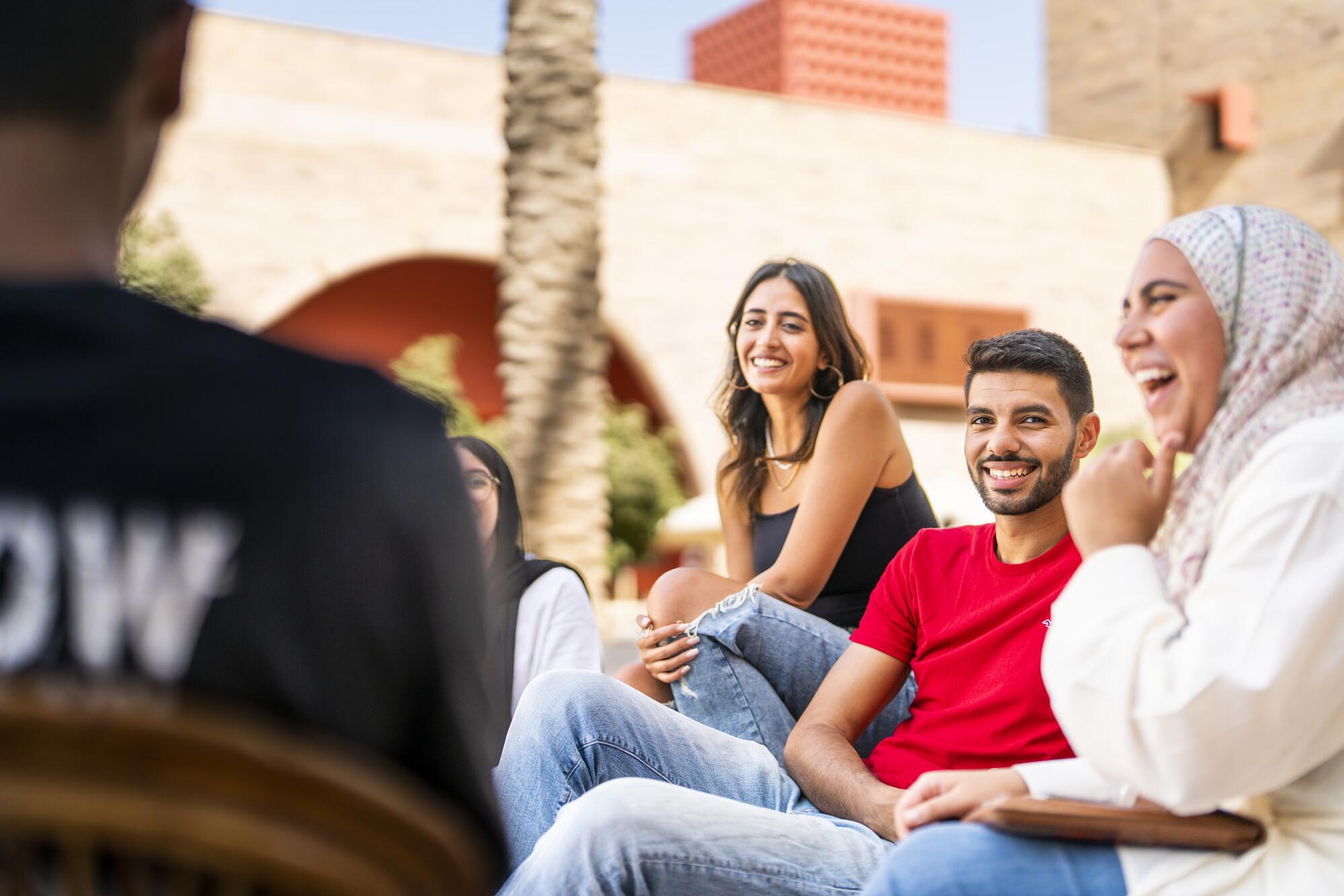 group of students smiling and talking in AUC campus