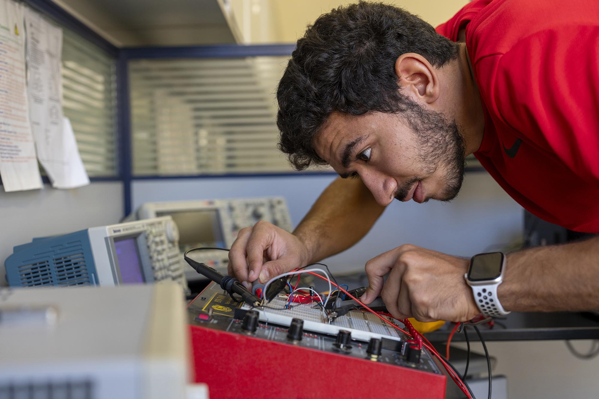 student working in engineering lab with electronic equipment