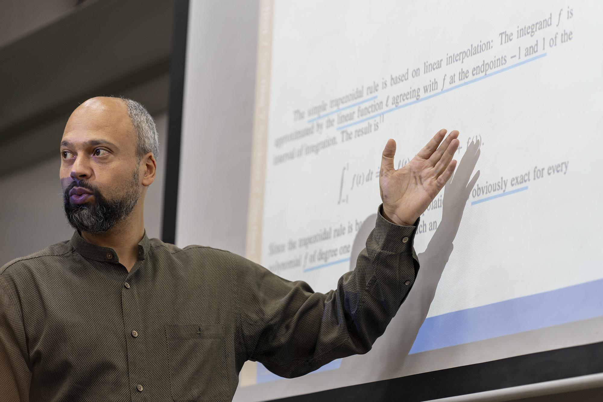 faculty explaining on white board to students in class room