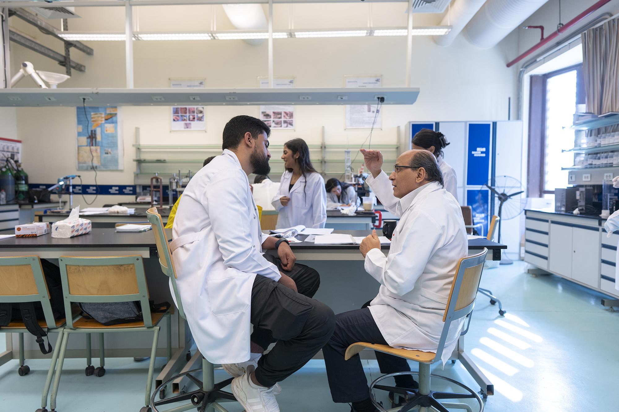 students working in lab wearing white coats