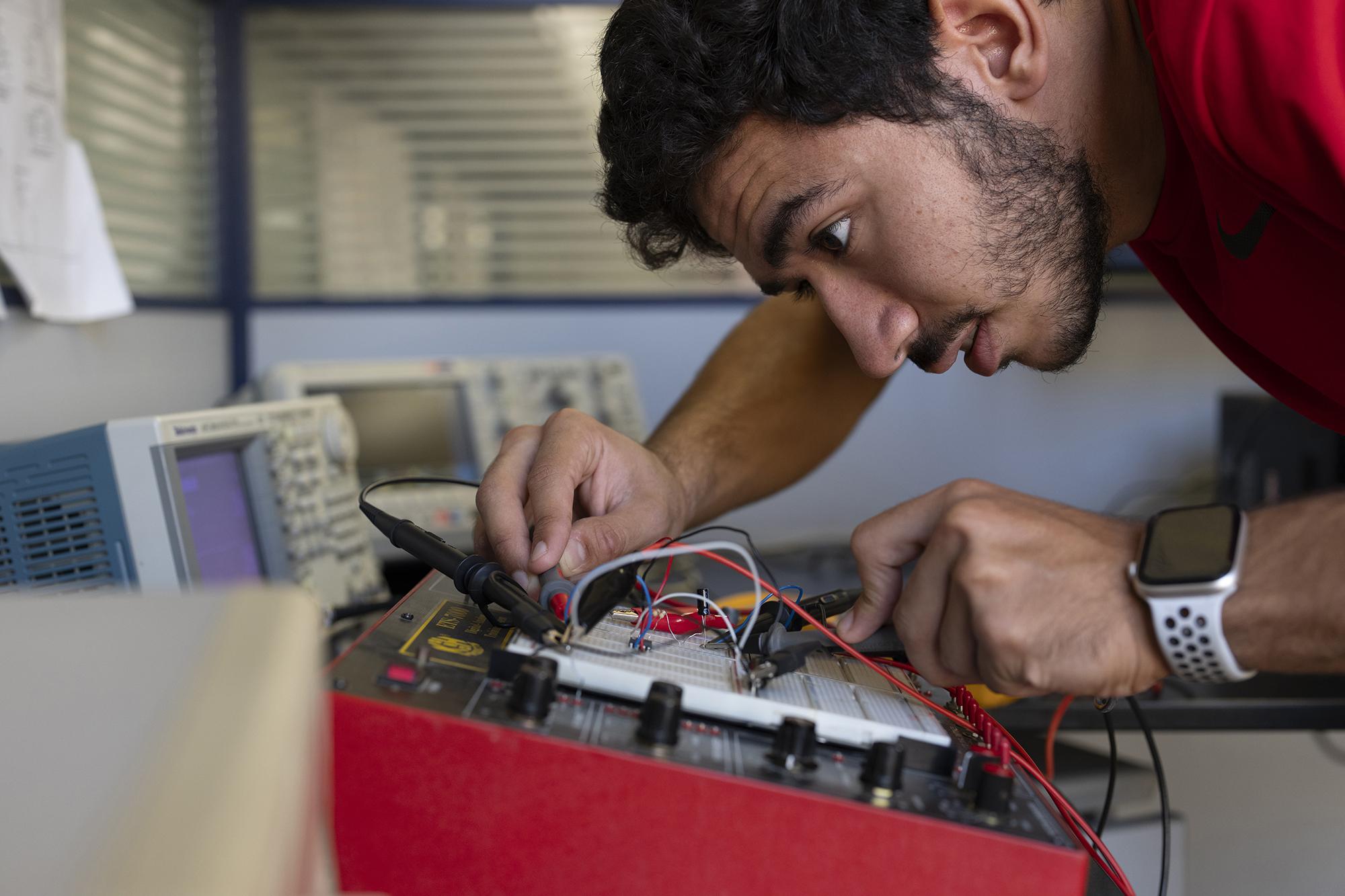 Student working with electronics equipment in engineering lab