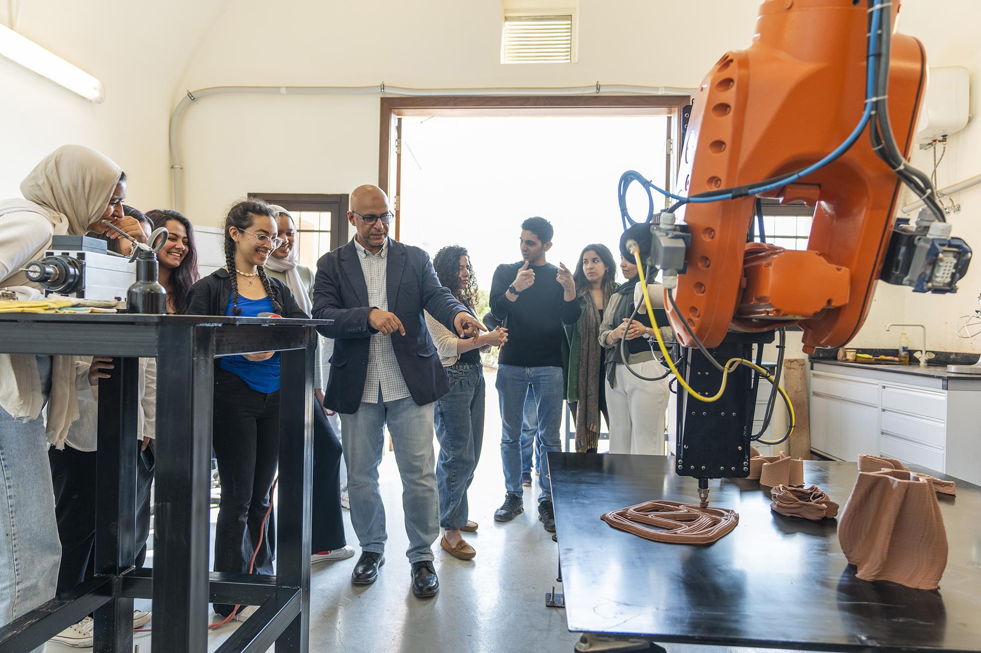 students in robotic arm lab working with professor 