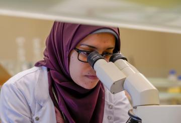 student looking into a microscope