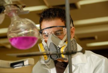 Student in chemistry lab with white coat