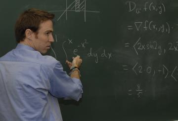 Professor explaining on board math equations
