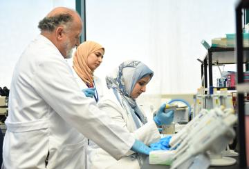 Hassan fawal and lab employees working in Human Ecology Lab with white coats