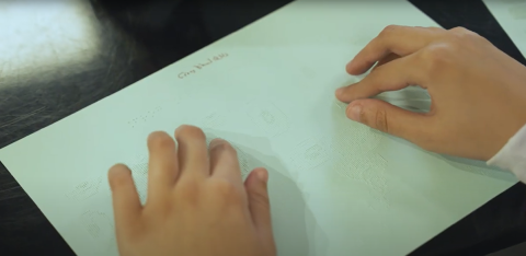 Two hands reading in Braille