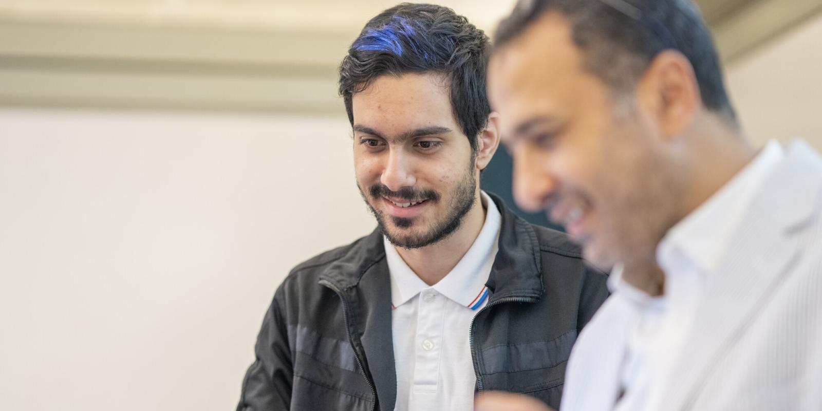 professor and student discussing information in front of classroom