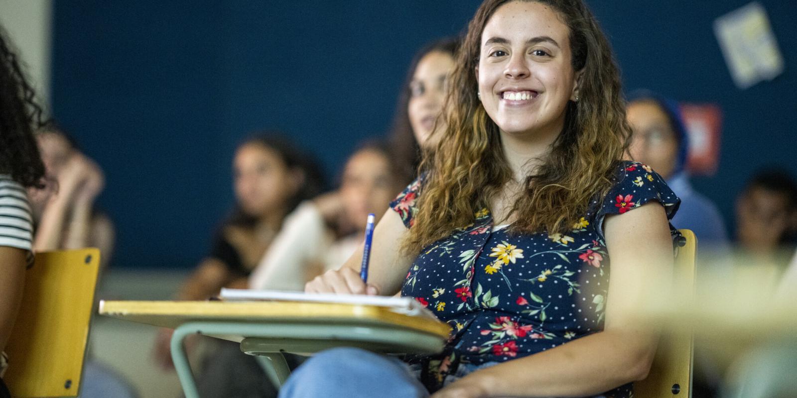 student in class taking notes