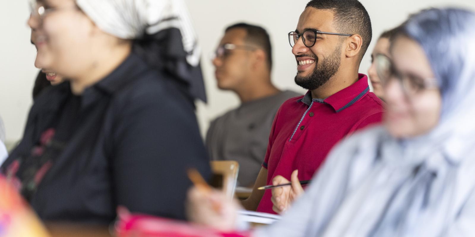 smiling students in class taking notes