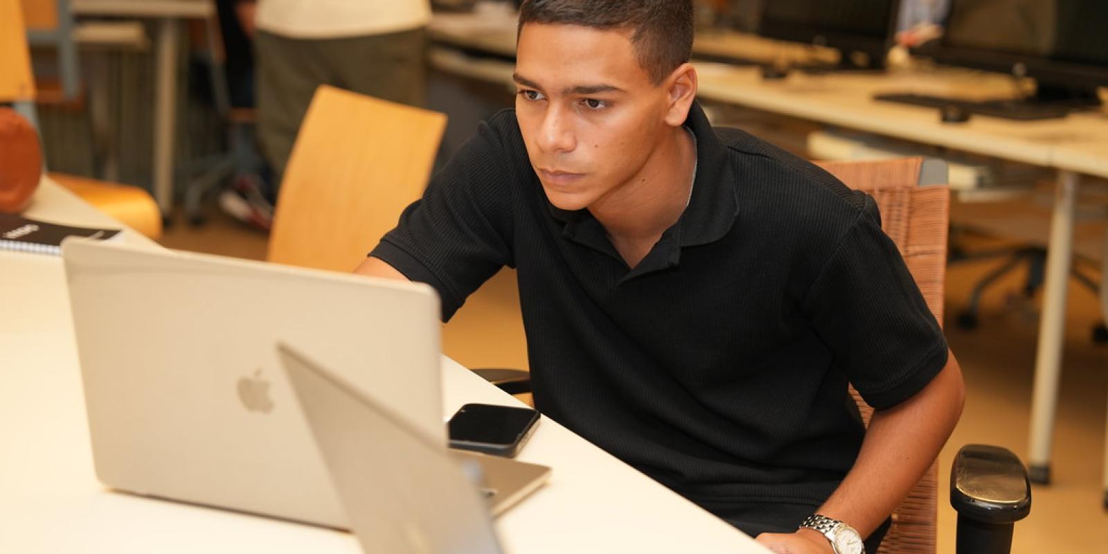 student working on laptop in computer lab