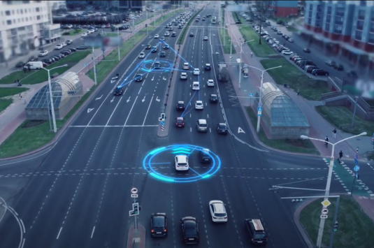A photo of a street with cars, with blue graphic visualizations of automated vehicle technology
