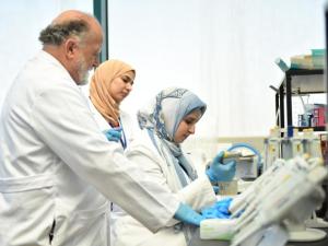 Global Health and Human Ecology Image of professor and students in white lab coats in science lab