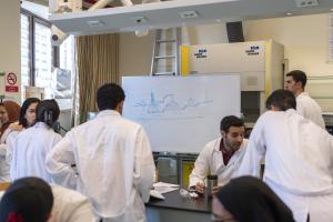 students in petroleum engineering lab wearing white coats