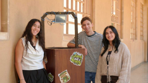 Three students stand in front of smart bin.