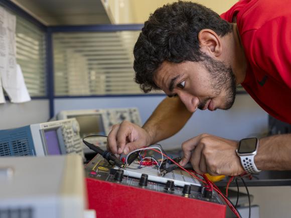 student working in engineering lab with electronic equipment