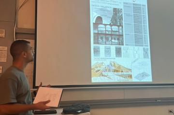 Student presenting his work on datashow in the classroom