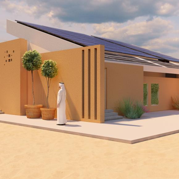 A solar house and a man standing beside the house. Green plant pots in front of the house