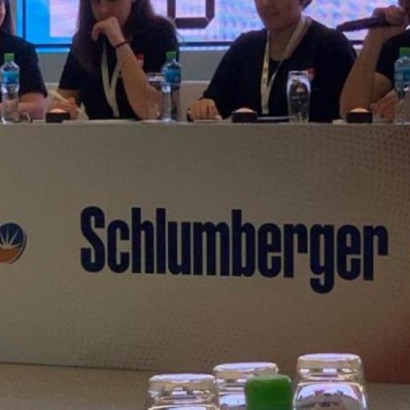 A group of girls and boys sitting on a panel in a conference