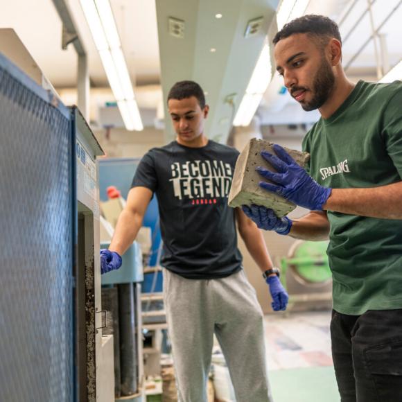 students working with cement in the construction lab